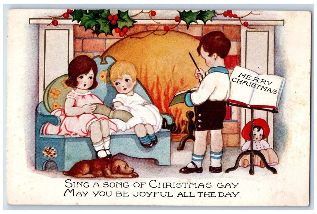 c1910's Christmas Fireplace Holly Carol Dog Doll Embossed Antique Postcard