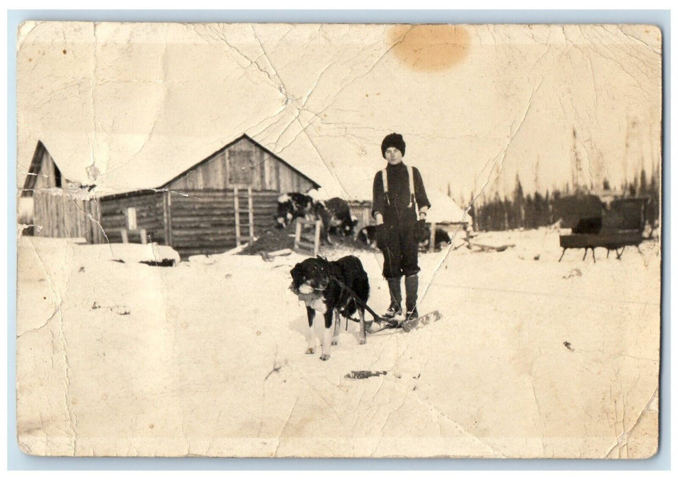 c1910's Child Riding Dog Sled Sleigh Cabin Canada RPPC Photo Vintage Postcard